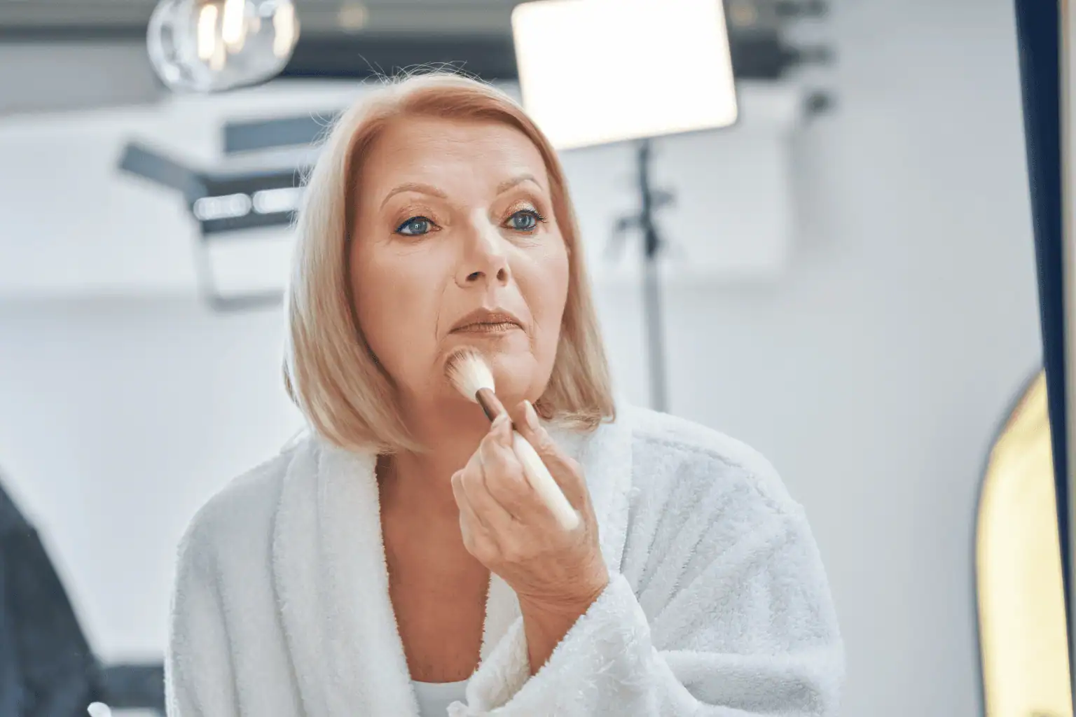 Senior applying makeup