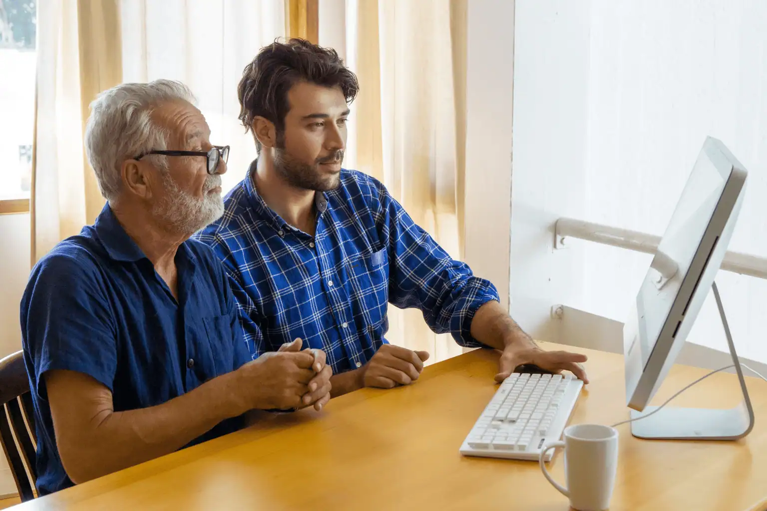Support worker helping senior use computer